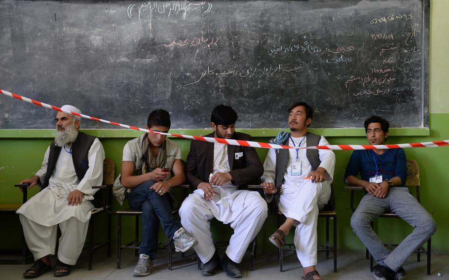 Election observers sit in their designated area at a polling station in a girls school in downtown Kabul during the second round of voting in the presidential election. Independent election monitoring organizations, as well as individual campaigns sent observers to many polling locations.