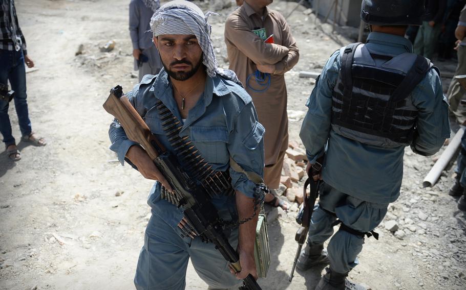 An Afghan policeman leaves the building where four Taliban militants lay dead after a firefight near Kabul's airport on July 17, 2014. International military officials say Afghan forces in Kabul have become adept at reacting to such attacks.