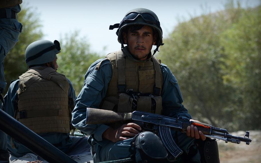 An Afghan policeman rides in the back of a truck during a patrol in Helmand province on Sept. 23, 2014.