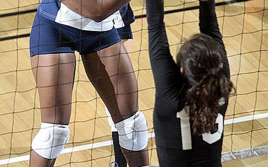 Seoul American's Destinee Harrison blasts a spike kill past the block of Osan American's Alina Hauter during Saturday's Korean-American Interscholastic Activities Conference girls volleyball match at Falcon Gym, Seoul American High School, South Post, Yongsan Garrison, South Korea. The host Falcons beat the Cougars 25-18, 25-17, 25-21.
