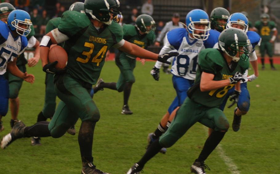 Dragon tailback Kerey Kuheana scrambles past a group of Rota defenders with downfield blocker Justin Thibodeua in front. Kuheana finished with 247 total yards and four TDs. Alconbury topped Rota, 46-6.