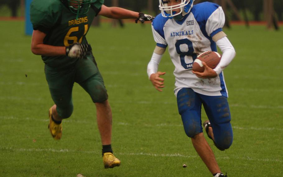 Rota's Carlos Shay breaks a run outside Saturday with Alconbury defender Taylor Williamson in pursuit. The Dragons downed the Admirals, 46-6.
 

