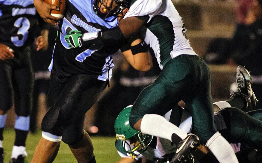 Osan American running back Dominic Oliveiro bulls his way through Daegu American's Tre Griffin during Friday's DODDS Korea high school football game at Cougars Field, Osan American High School, Osan Air Base, South Korea. Daegu won 28-6, punching its ticket to its second straight Far East Division II title game Nov. 6 at Zama American.