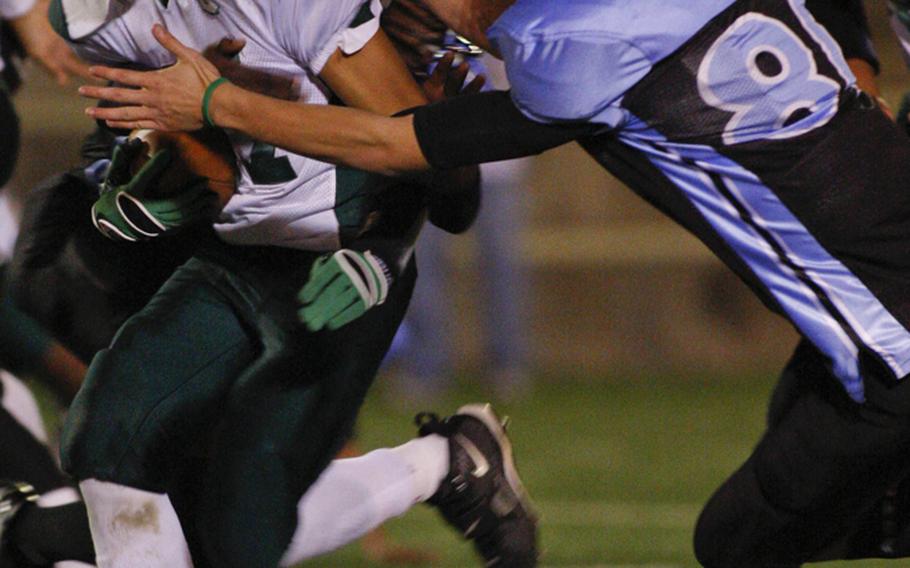 Daegu American's Ryan Banzon looks for running room against Osan American's Michael Benson during Friday's DODDS Korea high school football game at Cougars Field, Osan American High School, Osan Air Base, South Korea. Daegu won 28-6, punching its ticket to its second straight Far East Division II title game Nov. 6 at Zama American.
