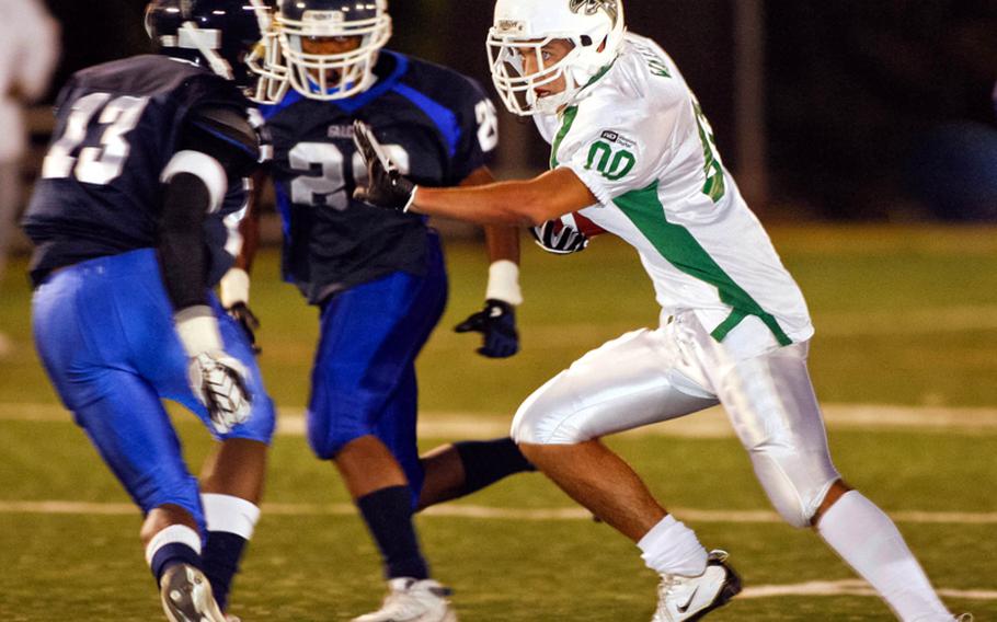 Singapore Falcons All-Stars running back Jake Walker looks for running room against Seoul American's Antoine Daniels , left, and Josh DeCastro during Saturday's interarea friendship high school football game at Sims Field, Seoul American High School, South Post, Yongsan Garrison, South Korea. The Falcons beat Seoul American, 24-8.