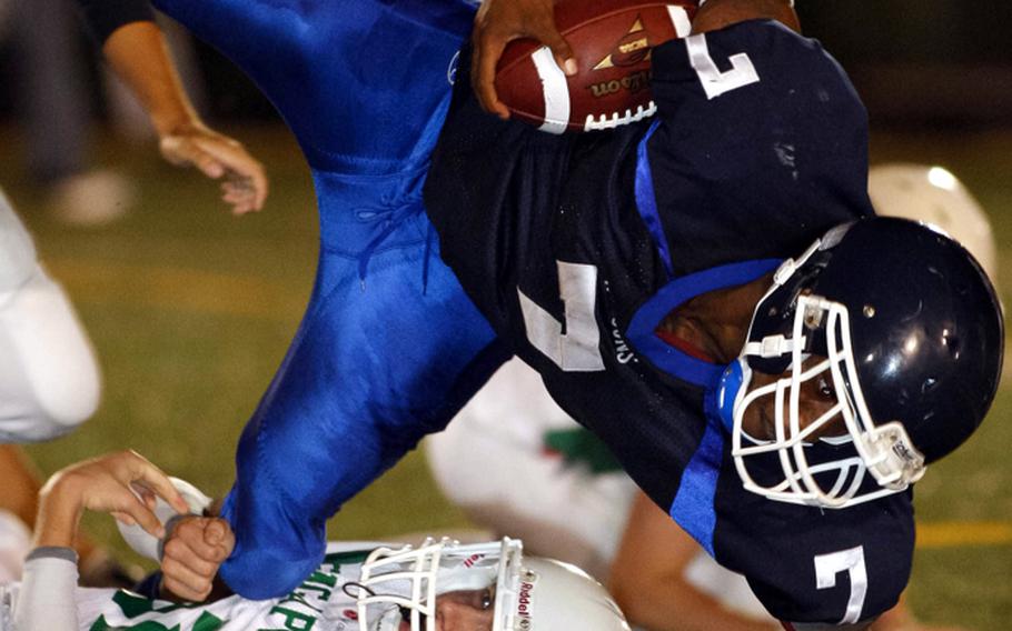 Seoul American's Tyrend White gets upended by Singapore Falcons Tyler Creasen during Saturday's interarea friendship high school football game at Sims Field, Seoul American High School, South Post, Yongsan Garrison, South Korea. The Falcons beat Seoul American, 24-8.