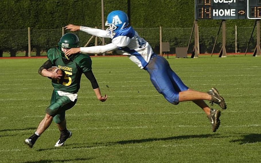  Rota's Cody Holland tries to bring down Dragon quarterback Jeff Black with a flying tackle during Alconbury's 34-14 victory Saturday.

