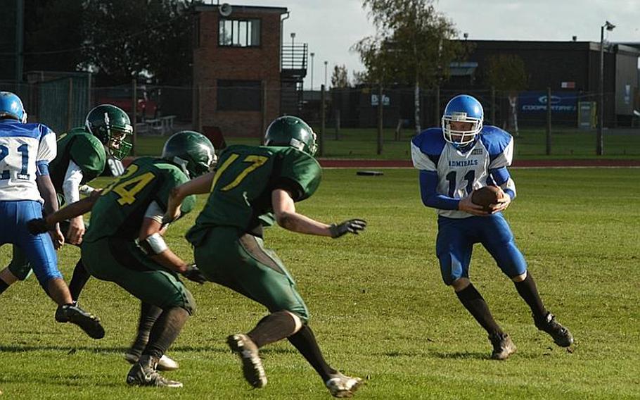 Rota's Kevin Banks runs into a wall of Dragon defenders led by  Beau Hocevar, right, and, Kerey Kuheana. Alconbury defeated Rota, 34-14, in a Division III playoff game.