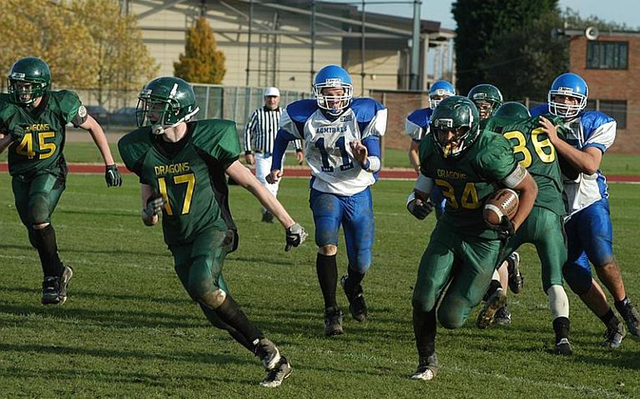 Dragon tailback Kerey Kuheana scrambles for yardage  behind lead blocker  Beau Hocevar as  Rota's Kevin Banks pursues during Alconbury's 34-14 win over Rota in a Division III playoff game.
 
