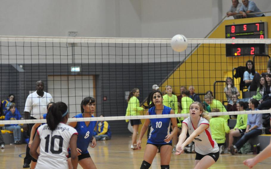 Alex Furrow from Menwith Hill prepares to bump the ball to her teammate, Alexis Thomas. Rota's Brianna Ammons, left, and Natalia Rivera watch from the other side of the net.  Rota defeated Menwith Hil 25-23, 24-26, 25-7, 21-25, 16-14 to capture the Division III girls volleyball title. 