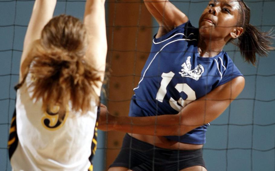 Seoul American's Destinee Harrison slams a spike past Aki Klemencic of American School In Japan during Friday's semifinal match in the Far East High School Girls Division I Volleyball Tournament at Falcon Gym, Seoul American High School, South Post, Yongsan Garrison, South Korea. Seoul American held off the Mustangs 25-23, 25-22 to reach Saturday's championship match against Faith Academy, 25-11, 25-15 winners over Nile C. Kinnick.