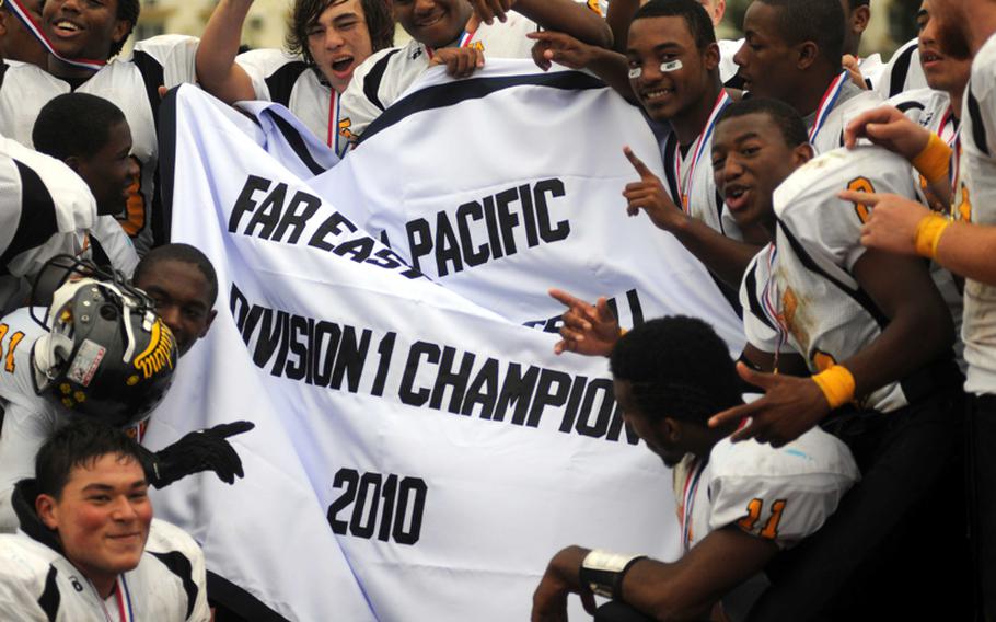 Kadena Panthers football players celebrate with the banner after Friday's Far East High School Division I football championship game at Mike Petty Stadium, Kubasaki High School, Camp Foster, Okinawa. Kadena routed Yokota, 50-23, for its second straight title and third in four years. 