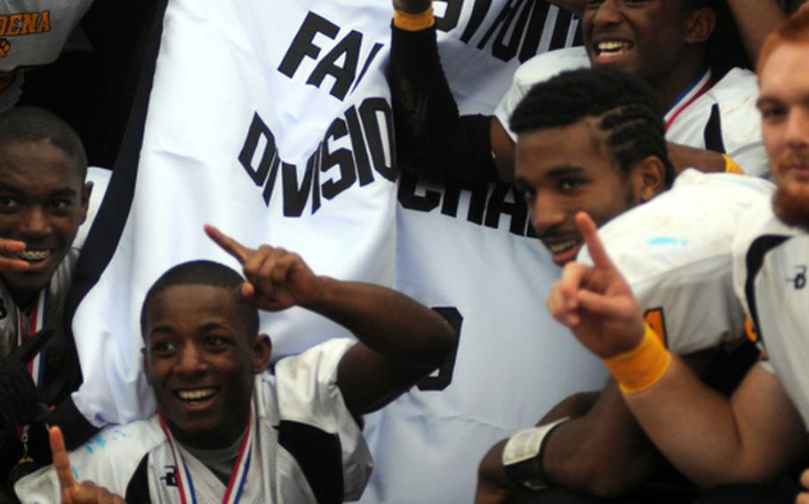 Kadena Panthers football players celebrate with the banner after Friday's Far East High School Division I football championship game at Mike Petty Stadium, Kubasaki High School, Camp Foster, Okinawa. Kadena routed Yokota, 50-23, for its second straight title and third in four years. 