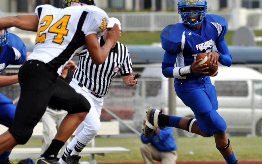 Yokota Panthers quarterback Myles Andrews looks for a receiver as Kadena Panthers defender Moises Charles gives chase during Friday's Far East Division I football championship game at Mike Petty Stadium, Kubasaki High School, Camp Foster, Okinawa. Kadena routed Yokota, 50-23, winning its second straight Division I title and third in four years.