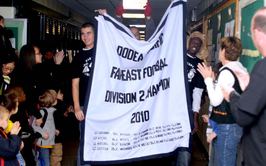 Students and teachers applaud as the Daegu American Warriors high school football team parades their Far East Division II championship banner through the halls at school Monday, a tradition at Daegu American for teams winning a Far East tournament title. Daegu's 28-2 Division II football title win at Zama American on Nov. 6 was the first time for the boys to do it since the 1990 Warriors boys basketball team won its third straight Division II title, and the first time the boys and girls had hoisted banners in the same season; the Warriors' girls volleyball team last week repeated its Division II title at Misawa Air Base, Japan.