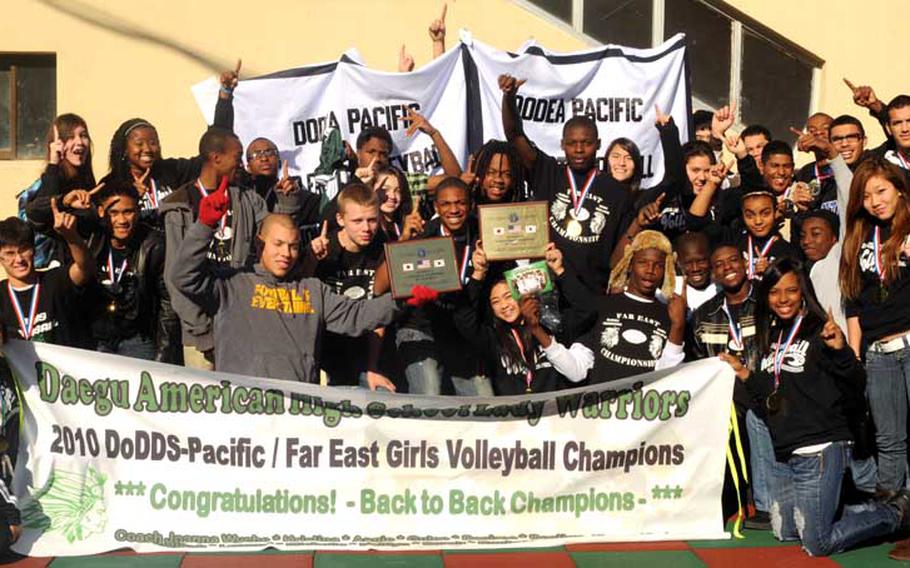 Daegu American football and girls volleyball players show who's No. 1 and show off their Far East Division II tournament spoils at school Monday, a tradition at Daegu American for teams winning a Far East tournament title.