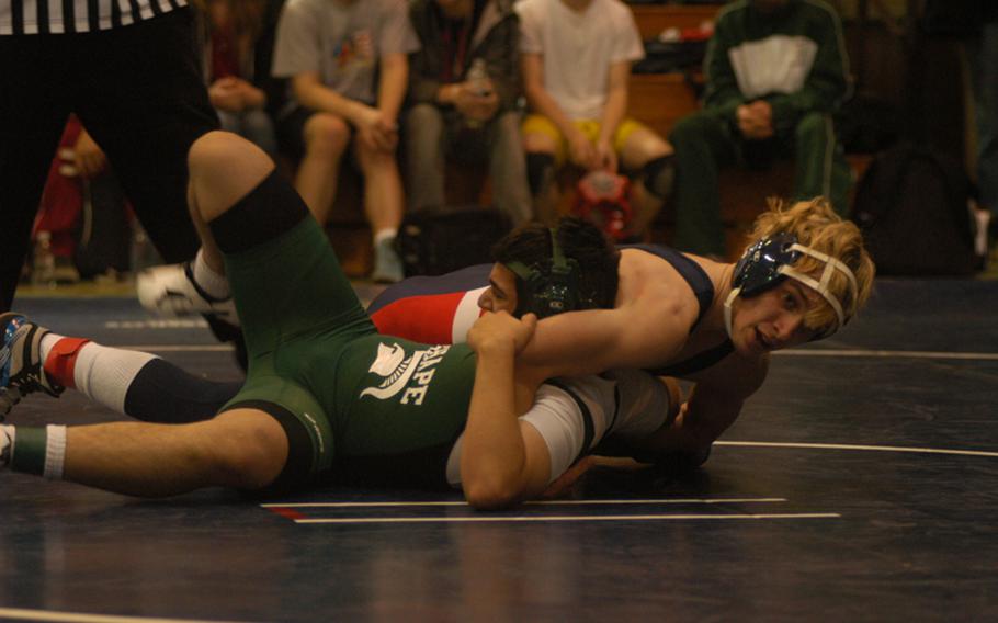 Lancer wrestler Devon Parrish attempts to pin SHAPE’s Isaac Somaranta during the year’s first meet Saturday at RAF Alconbury. 