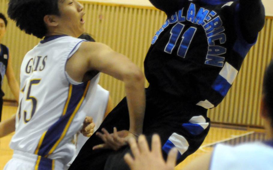 Seoul American Falcons' D.J. Lawrence shoots over Allen Jang of Gyeonggi Suwon International Knights during Friday's elimination playoff game in the 2011 Korean-American Interscholastic Activities Conference Boys Division I Basketball Tournament at Gyeonggi Suwon International School, South Korea. The Falcons beat the Knights, 62-11.