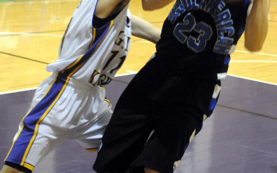 Seoul American Falcons John Graham gets fouled as he shoots by Gyeonggi Suwon International Knights' Thomas Lim during Friday's elimination playoff game in the 2011 Korean-American Interscholastic Activities Conference Boys Division I Basketball Tournament at Gyeonggi Suwon International School,  South Korea. The Falcons beat the Knights, 62-11.