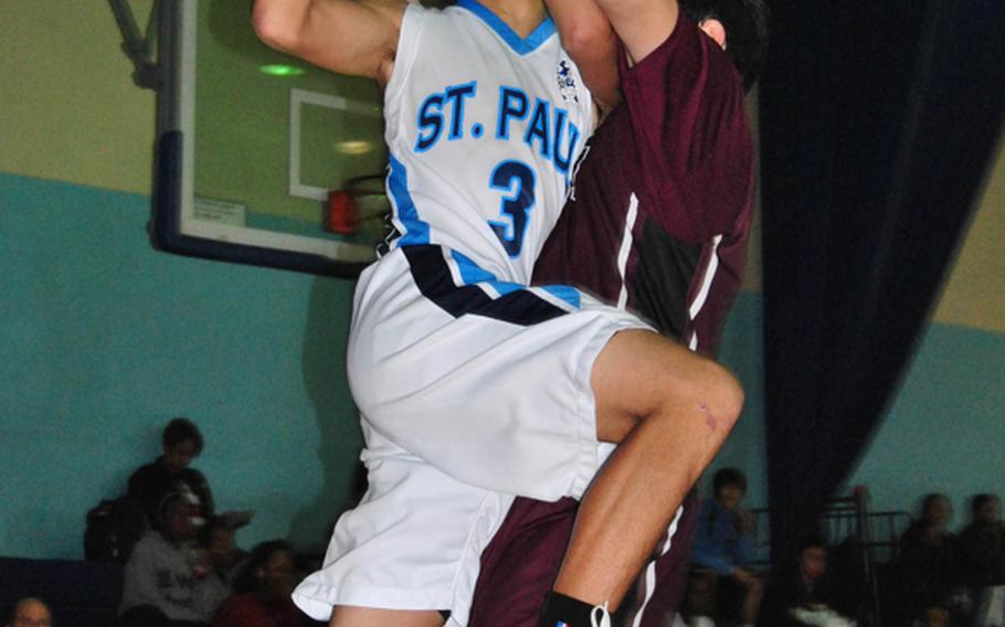 Eric Canovas of St. Paul Christian rams into a Matthew C. Perry defender during Wednesday's double-elimination playoff game in the Far East High School Boys Division II Basketball Tournament at Kelly Fitness & Sports Center, Camp Walker, South Korea. St. Paul beat Perry for the second time in the tournament, 50-43.