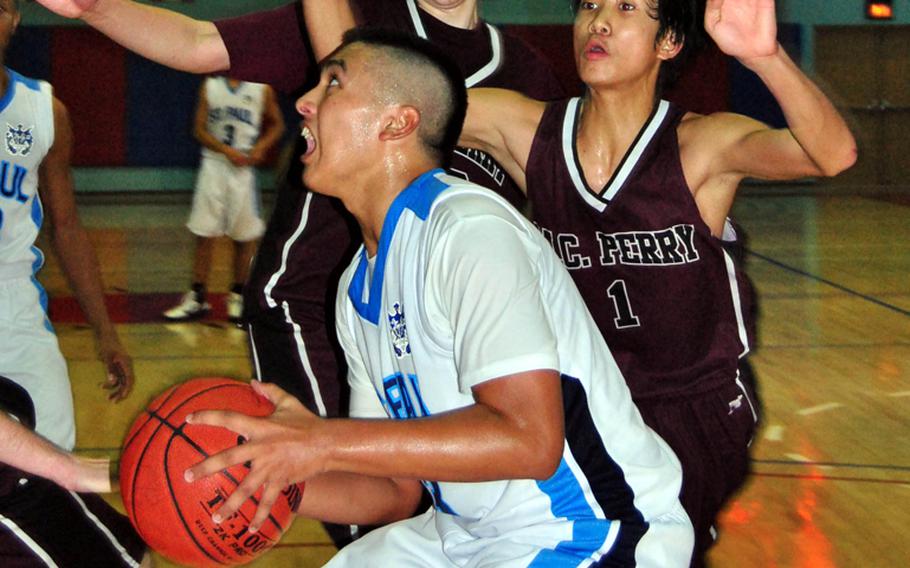 Mark Canovas of St. Paul Christian puts up a shot against two Matthew C. Perry defenders during Wednesday's double-elimination playoff game in the Far East High School Boys Division II Basketball Tournament at Kelly Fitness & Sports Center, Camp Walker, South Korea. St. Paul beat Perry for the second time in the tournament, 50-43.