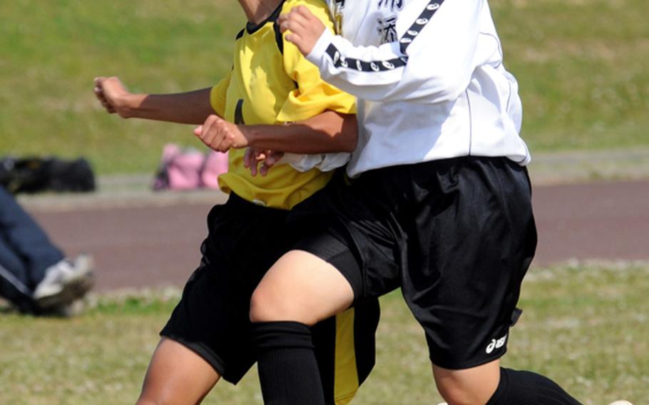 Kadena's Alisia Barcinas and Urasoe's Konomi Mikawadori collide as they try to head the ball during Sunday's girls high school soccer match at Kadena High School, Okinawa. Urasoe, a Japanese team, blanked Kadena, 2-0.