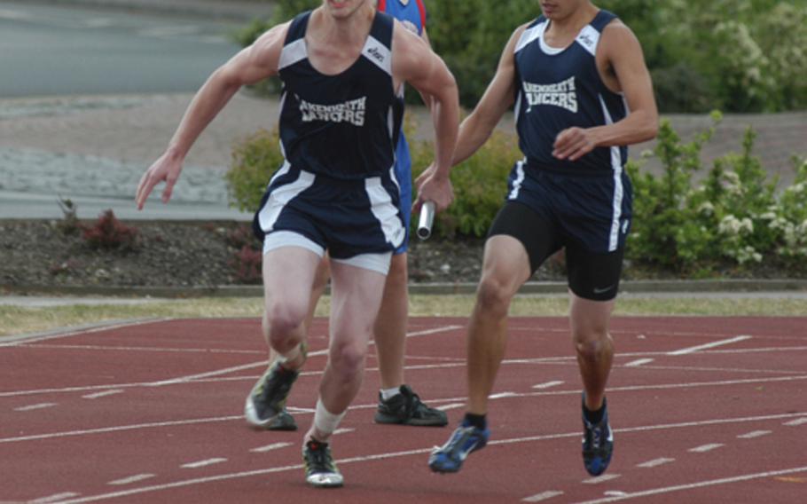 Lakenheath's Chace Smith grabs the baton from teammate Nick Ruiz during the 4x100-meter relay at a track meet at RAF Lakenheath, England, on Saturday. The Lancers were disqualified for an illegal handoff -- too early -- between Ruiz and Smith. 