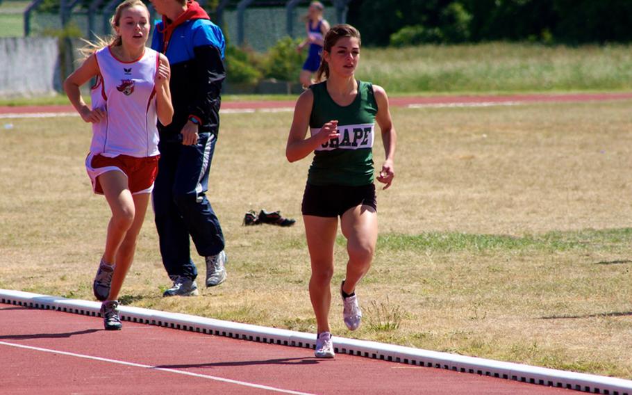 SHAPE Junior Mishal Cotugno outdistances International School of Brussels runner Maitre Smith on Saturday at Chievres, Belgium,  en route to setting a  school record of 2 minutes, 24.74 seconds in the 800 meters. Cotugno’s time beat the Lady Spartans’ previous best of 2:27.34, run in 2003 by Amanda Terry, according to SHAPE coach Mike Vargas.
