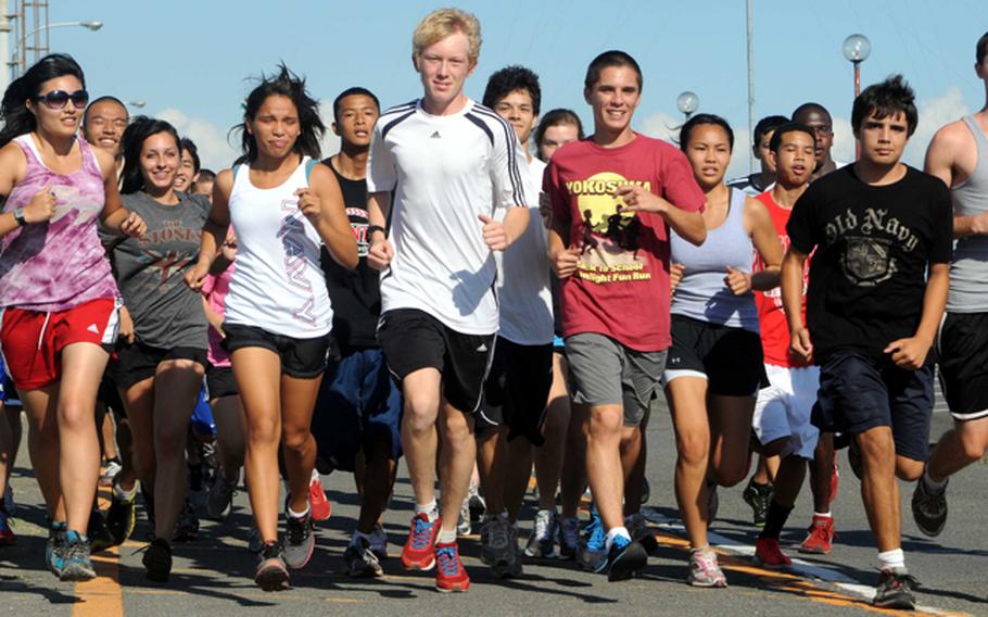 Nile C. Kinnick Red Devils cross-country sophomore Carydaliz Fontanez and junior Robert Beard, each in white, are setting the pace among DODDS runners in Japan. Beard currently holds the second-best 3.1-mile race time among DODDS Pacific runners with a 17 minutes, 27 seconds.  Fontanez finished third in the first DODDS Japan meet at Isanoura Park near Sasebo Naval Base on Sept. 3, but finished first among DODDS Japan runners Saturday on the 2.1-mile Tama girls course.