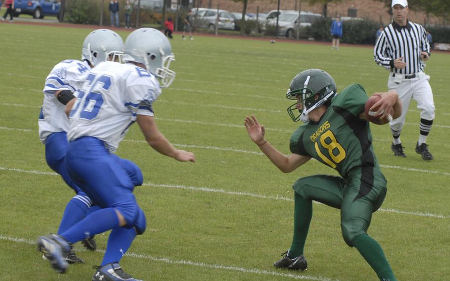 Dragon quarterback Justin Thibodeau changes direction in an effort to avoid two Brigand defenders, Dakota Deverill and Will Cole.