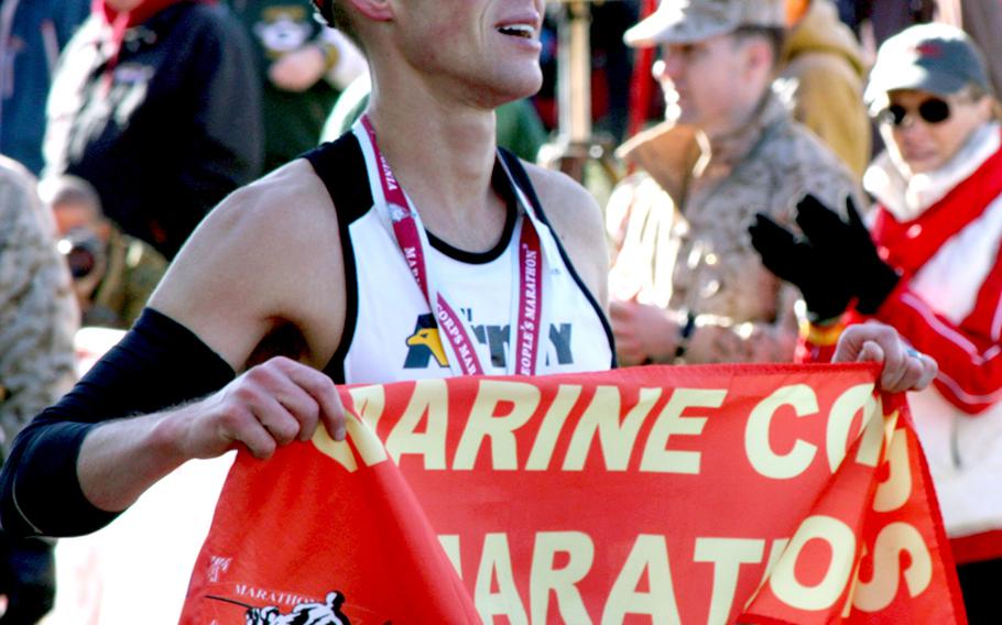 U.S. Army 1st Lt. Chad Ware of Wheeling, Ill., holds the finish tape after winning in an unofficial time of 2 hours, 19 minutes and 16 seconds.