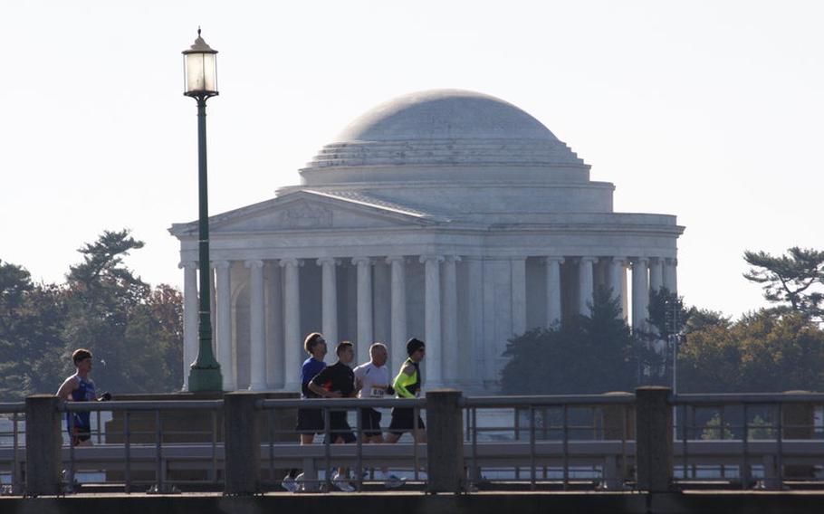 Runners cross a bridge near the Jefferson Memorial.