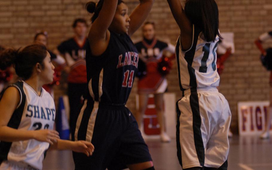 Lakenheath's Jourdan Hodge looks to pass the ball while SHAPE defenders Eugina Rhett,right, and Jamie Gamboa try to disrupt the play. SHAPE's full-court press gave the Lancers trouble during their two matchups on the weekend.