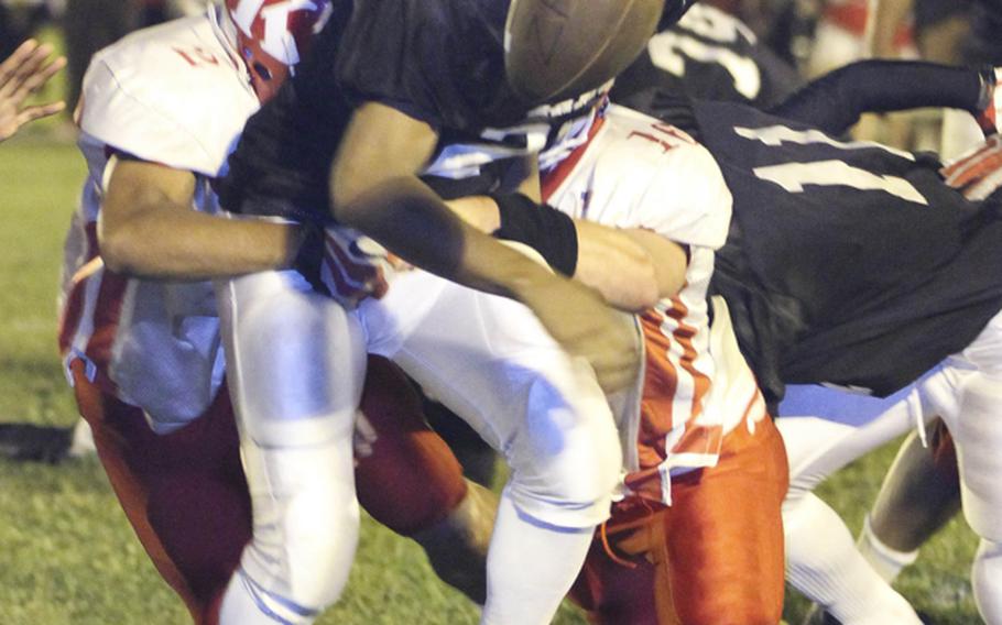 Zama ball carrier Rafael Morales has the ball stripped out of his hands during Friday's DODDS Japan/Kanto Plain Association of Secondary Schools high school football season-opening game at Naval Air Facility Atsugi, Japan. Kinnick rallied to beat Zama 20-6.