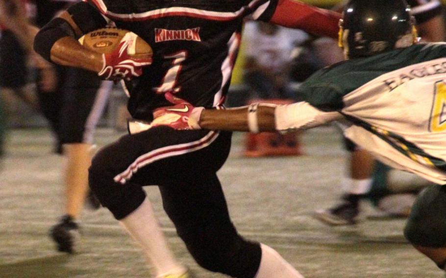 Nile C. Kinnick Red Devils running back Quinton Holden looks for running room against the Robert D. Edgren Eagles defense during Friday's DODDS Japan inter-division high school football game at Berkey Field, Yokosuka Naval Base, Japan. Kinnick edged Edgren 29-26.