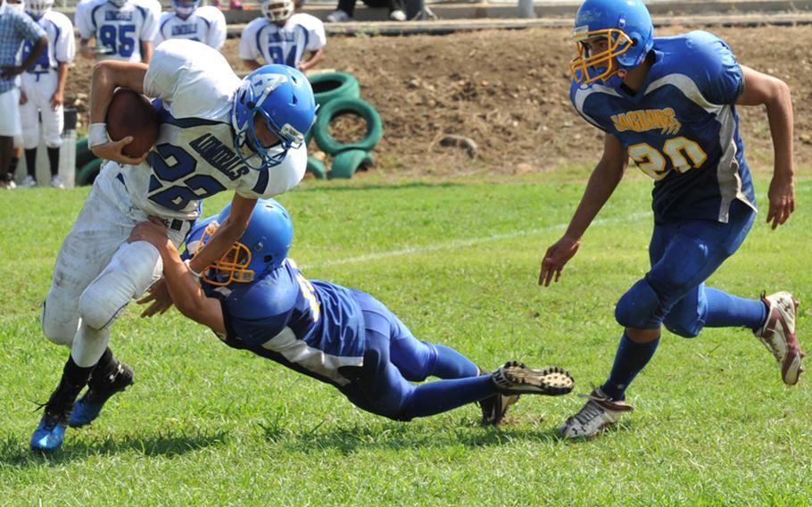 Rota's Mason Crowell tries to break a tackle during the Admirals' 42-0 season-opening victory over the Sigonella Jaguars on Saturday.