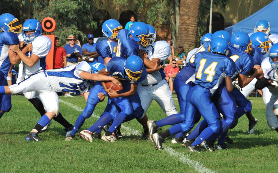 Rota's Colton Lippman tries to strip the ball Saturday during the Admirals' 42-0 victory over the Sigonella Jaguars in the two teams' season-opening football game in Sicily.