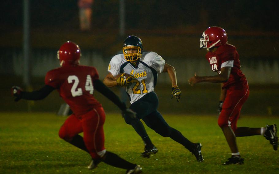 Heidelberg's Chaz Anderson makes a move on two Kaiserslautern defenders Friday night. Heidelberg went on to win 18-13.