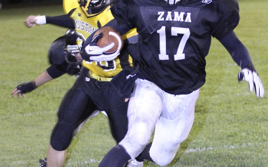 Zama American running back Mitchell Harrison eludes the tackle of American School In Japan defender Taichi Nishiwaki during Friday's Kanto Plain Association of Secondary Schools football game at Camp Zama, Japan. ASIJ won 24-8.
