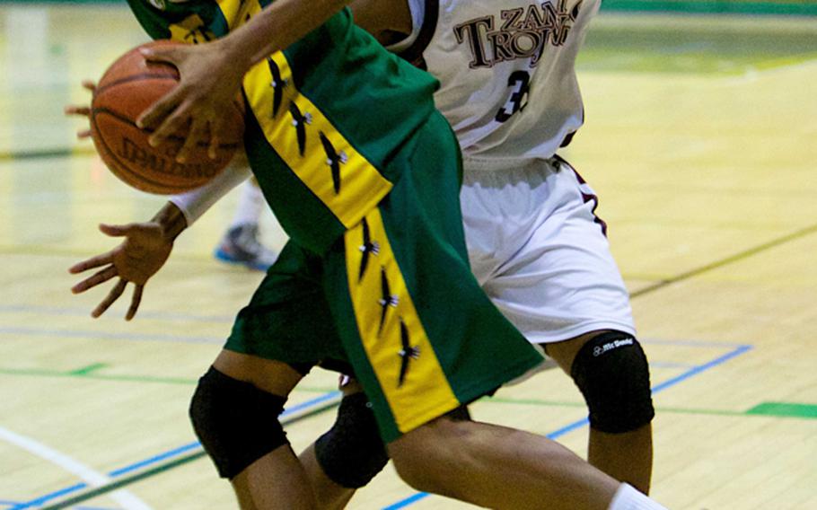 Robert D. Edgren's Quin White drives around Zama American's Andrae Adams during a DODDS Japan basketball tournament boys game at  Misawa Air Base, Japan. Adams transferred to Zama from American School In Japan and has been called the final piece of the puzzle that led the Trojans to the Far East Division II title, coach Parish Jones said. Adams has been named Stars and Stripes Pacific high school boys basketball Player of the Year.