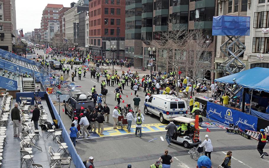Emergency personnel assist the victims at the scene of a bomb blast during the Boston Marathon in Boston, Massachusetts, Monday, April 15, 2013. 