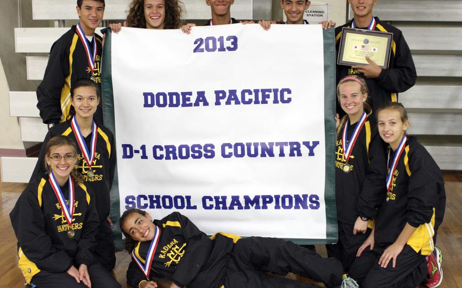 Kadena runners gather 'round the Division I banner inside Halsey Fitness & Sports Center following Tuesday's team relay in the Far East High School Cross-Country Meet at Naval Air Facility Atsugi, Japan. The Panthers won everything there was to be won in the meet, both boys and girls individual races, boys, girls and overall school championships, the team relay points and placed all four of its relay pairs in the top four.