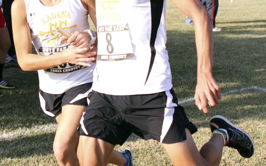 Kadena seniors and two-time Far East champions Ana Hernandez and Andrew Kilkenny exchange the baton during Tuesday's team relay in the Far East High School Cross-Country Meet at Naval Air Facility Atsugi, Japan. Kilkenny crossed the line first and Kadena won the Division I team relay, placing its four pairs in the top four.