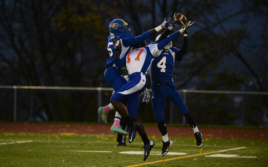 South squad's Jayontray Grogan intercepts a pass intended for North squad's CJ Pridgen with help from teammate Brian Debel ON Saturday night in the DODDS-Europe high school football all-star game in Wiesbaden, Germany.