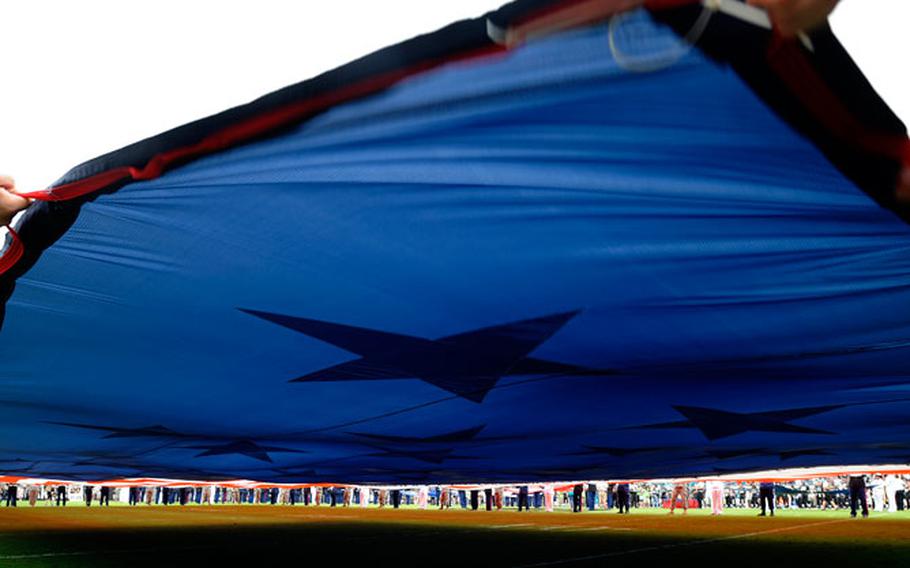 Members of the military wave a large American flag on EverBank Field before the start of an NFL football game between the Jacksonville Jaguars and Arizona Cardinals, Sunday, Nov. 17, 2013, in Jacksonville, Fla. The Cardinals beat the Jaguars 27-14.