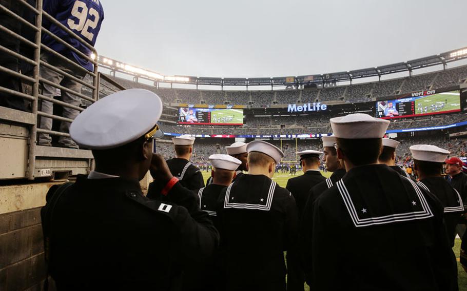 Members of the U.S. Navy observe the field at MetLife Stadium before an NFL football game between the New York Giants and the Green Bay Packers Sunday, Nov. 17, 2013, in East Rutherford, N.J.