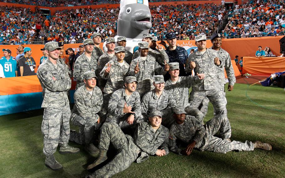 Service members pose with Miami Dolphins mascot "Air T.D." during a 'Salute to Service' event in the second half of an NFL football game between the Miami Dolphins and the San Diego Chargers, Sunday, Nov. 17, 2013, in Miami Gardens, Fla. The Dolphins defeated the Chargers 20-16.