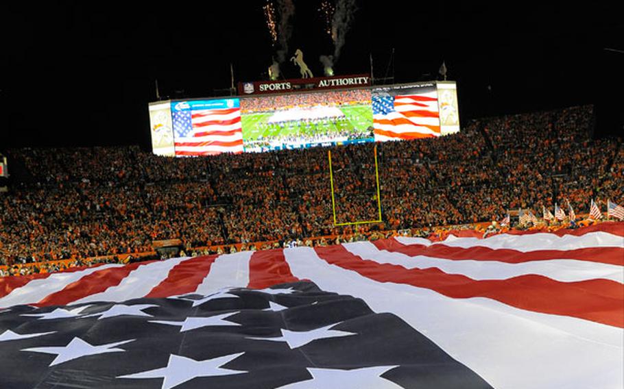 A giant American flag is stretched across the field during the national anthem before an NFL football game between the Denver Broncos and the Kansas City Chiefs, Sunday, Nov. 17, 2013, in Denver.