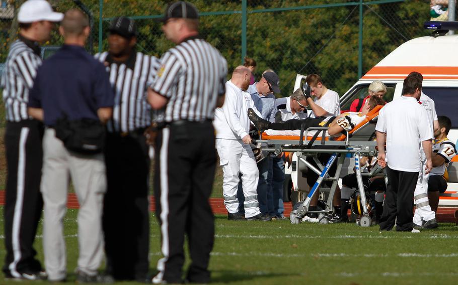 Officials confer as a handful of Patch players are attended to by medical personnel, moments before Patch coach Brian Hill threw in the towel with nearly nine minutes left to play in a DIvision I semifinal game at Ramstein, Oct. 26, 2013. Hill told his team the game was out of reach, and he didn't want to see more of his players hurt. 

