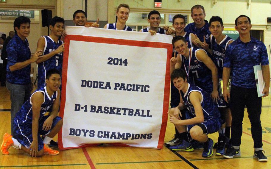 Faith Academy players and coach Robby Nichols, right, celebrate with the banner following Thursday's 77-52 win over host Kubasaki in the 66th Far East High School Boys Division I Basketball Tournament.